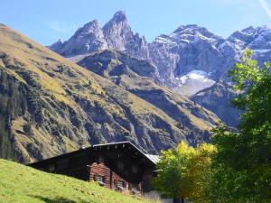een gebouw op een heuvel met bergen op de achtergrond bij Ferienwohnung Landhaus Martin in Sonthofen +46 foto's