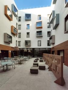un edificio con mesas y sillas en un patio en Hotel Macià Sevilla Kubb, en Sevilla