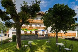 a building with tables and chairs in the grass at Landgasthof Bauerngirgl in Bayerisch Gmain