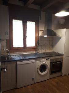 a kitchen with a washing machine and a dishwasher at La Zamarriega in Segovia