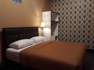 - un lit avec deux oreillers et une tête de lit dans la chambre dans l'établissement Ma Maison Guest House, à Yogyakarta