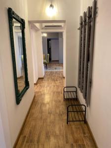 a hallway with a mirror on the wall and chairs at Dominic Apartment Unirii Square in Timişoara