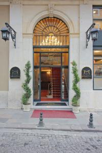 Meserret Palace Hotel - Special Category في إسطنبول: مدخل إلى مبنى يوجد أمامه اثنين من النباتات الفخارية