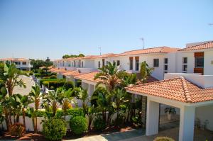 a row of white houses with trees and plants at Atlantis Gardens in Mazotos