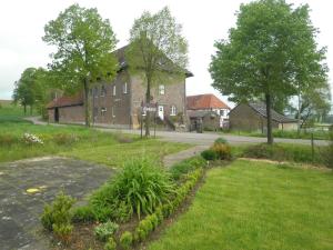 a large brick building with a road in front of it at B&B Einrade in Vaals