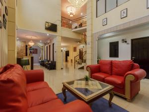 uma sala de estar com dois sofás vermelhos e uma mesa em RedDoorz Plus near Pantai Malalayang Manado em Manado