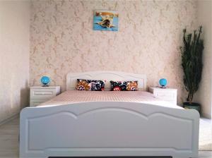 a white bed in a bedroom with pink wallpaper at MEGAPOLIS улица Большая Манежная 13-В-77 in Voronezh