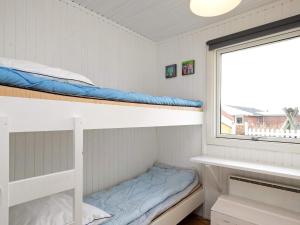 two bunk beds in a room with a window at 6 person holiday home in Ringkøbing-By Traum in Søndervig