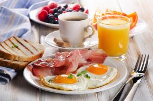 a breakfast plate with eggs and toast and a cup of coffee at Hotel Vetraz in Vitebsk