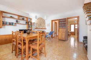 uma cozinha e sala de jantar com uma mesa de madeira e cadeiras em Son Homs em Colonia Sant Jordi