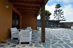 un patio con sillas y mesas blancas y un árbol en Villa Nelida peace lovers Vegueta By PVL, en La Vegueta