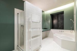 y baño con ducha, lavabo y bañera. en Stay COOPER l Cooper apartments, en Bolzano