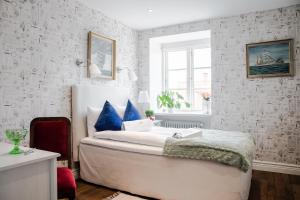 ein Schlafzimmer mit einem Bett mit blauen Kissen in der Unterkunft Höörs Gästgifwaregård in Höör