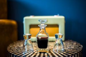 a decanter with two small bottles on a table at The Lodge Duxford in Duxford