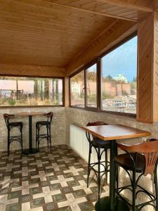 a room with two tables and chairs and windows at Georgian Palace Hotel in Kutaisi