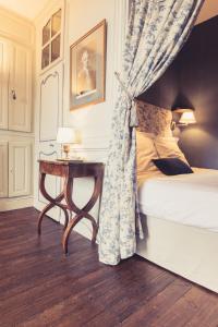 - une chambre avec un lit et une table avec un rideau dans l'établissement La Maison de la Liberté Jean-François de La Pérouse, à Poitiers