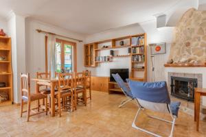 uma sala de jantar com uma mesa e cadeiras e uma lareira em Son Homs em Colonia Sant Jordi
