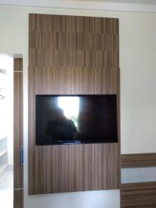 a flat screen tv in a wooden wall at Apartamento Lacqua Di Roma in Caldas Novas