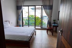 a bedroom with a bed and a large window at Căn Hộ dịch vụ cao cấp Sân Bay Tân Sơn Nhất in Ho Chi Minh City