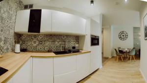una cucina con armadi bianchi e un tavolo in una stanza di Apartament Silence Triventi Silver View a Karpacz