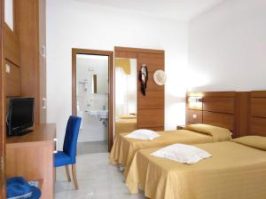 a hotel room with two beds and a television at Villaggio Turistico La Mantinera - Hotel in Praia a Mare