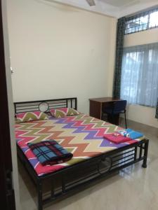 a bedroom with a bed with a colorful comforter at Cozy Living in Guwahati +16 photos