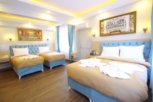 a hotel room with two beds and a couch at Hira Hotel in Istanbul