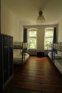 a room with three bunk beds and two windows at 36 Rooms Hostel Berlin Kreuzberg in Berlin