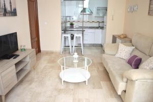uma sala de estar com um sofá e uma mesa em Apartamentos La Caleta de Cadiz em Cádiz