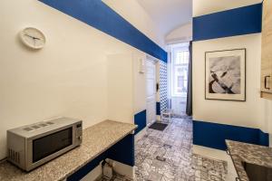 Habitación azul y blanca con TV y barra. en Sweet Home by Ruterra, en Praga