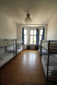 um quarto com 3 beliches e uma janela em 36 Rooms Hostel Berlin Kreuzberg em Berlim