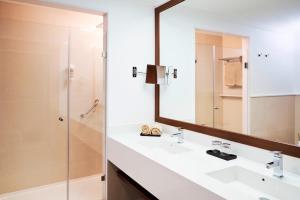 a bathroom with two sinks and a mirror at TUI BLUE Falesia - Adults Only in Olhos de Água