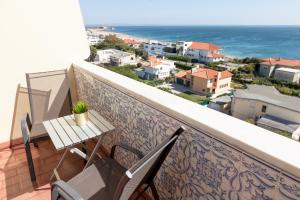 a balcony with a table and chairs and the ocean at Carcavelos Beach Hotel in Carcavelos