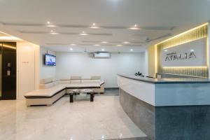 een lobby met een wachtkamer met een bank en een tafel bij Manipal Atalia Service Apartments in Manipala