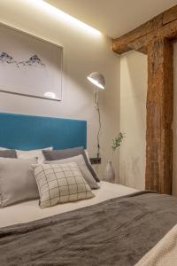 een slaapkamer met een groot bed met een blauw hoofdeinde bij New Soho AC by Staynnapartments in Bilbao