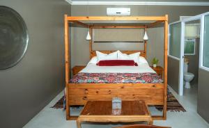 a bedroom with a bed with a wooden bed frame at iGwalagwala Guest House in St Lucia