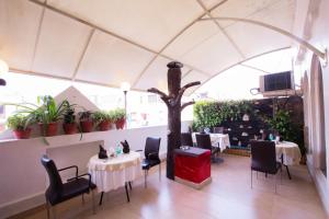 a restaurant with two tables and a tree in the middle at HOTEL SURYA INTERNATIONAL in New Delhi