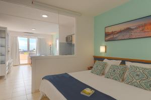1 dormitorio con cama y vistas a un balcón en Palm Garden Jandía By CanariasGetaway, en Morro del Jable