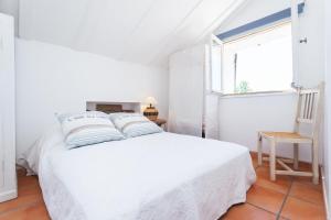 a white bedroom with a white bed and a window at Appartements Vieux Nice / Marché aux fleurs in Nice