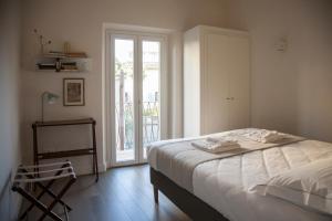 a bedroom with a bed and a door to a balcony at Pietrapiana Boutique Apartments in Florence