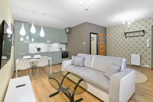 un soggiorno con divano e una cucina di Krupnicza Premium Apartments a Cracovia