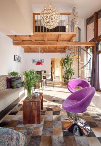 ein Wohnzimmer mit einem lila Stuhl und einer Couch in der Unterkunft Apartments Pri nas in Kobarid