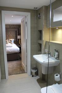 a bathroom with a sink and a bedroom with a bed at The Lord Street Hotel; BW Signature Collection in Southport