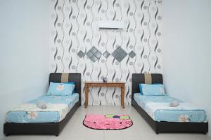 een kamer met 2 bedden en een tafel bij Padang Besar Twin Homestay in Padang Besar