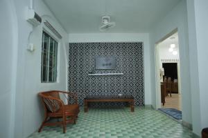 een woonkamer met een stoel en een tafel bij Padang Besar Twin Homestay in Padang Besar