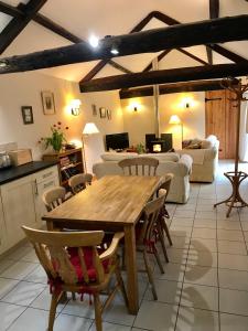 a kitchen and living room with a wooden table and chairs at The Old Coach House in Pen-pergwm +4 photos