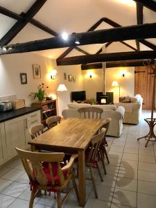 a kitchen and living room with a wooden table and chairs at The Old Coach House in Pen-pergwm