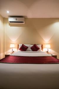 um quarto com uma cama grande e almofadas vermelhas em Bukoto Heights Apartments em Kampala
