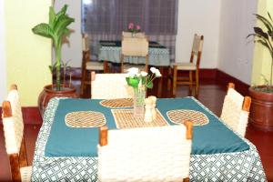 une table avec un chiffon de table bleu et des fleurs sur elle dans l'établissement MUHABURA MOUNTAIN LODGE, à Gisenyi
