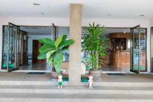 dos muñecas de pie frente a un edificio con plantas en Tokyo Hotel, en Ubon Ratchathani